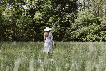 Italien, Venetien, Junge Frau pflückt Blumen und Kräuter auf einem Feld - ALBF00410