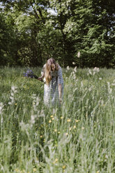 Italien, Venetien, Junge Frau pflückt Blumen und Kräuter auf einem Feld - ALBF00413