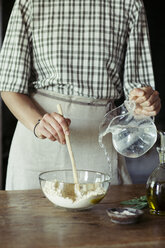 Junge Frau in der Küche bei der Zubereitung von Teig für frischen Kichererbsenkuchen - ALBF00445