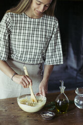 Junge Frau in der Küche bei der Zubereitung von Teig für frischen Kichererbsenkuchen - ALBF00448
