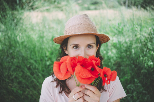 Frau hält einen Strauß roter Mohnblumen im Frühling - GEMF02068