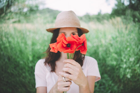 Frau hält einen Strauß roter Mohnblumen im Frühling - GEMF02069