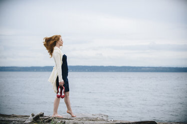 Junge Frau am Strand mit Blick aufs Meer, Bainbridge Island, Washington State, USA - ISF09659
