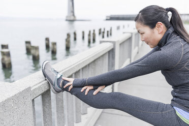 Läuferin beim Stretching auf einer Brücke, San Francisco, Kalifornien - ISF09669