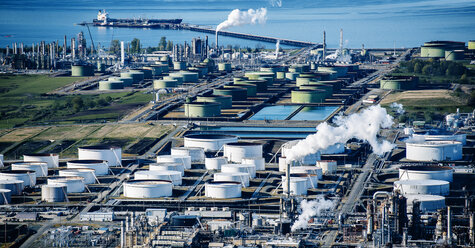 High angle view of white oil storage tanks in coastal oil refinery - ISF09688
