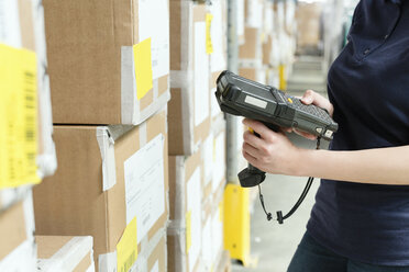 Cropped view of warehouse worker using barcode scanner on box in distribution warehouse - CUF31396