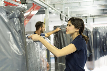 Warehouse workers preparing garment orders in distribution warehouse - CUF31408