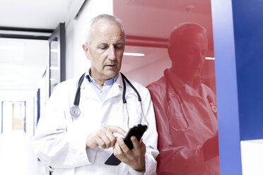 Male doctor using smartphone - CUF31430
