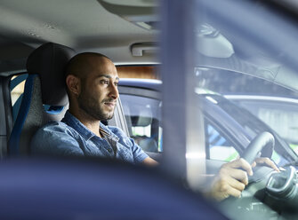 Junger Mann fährt Elektroauto - CVF00788