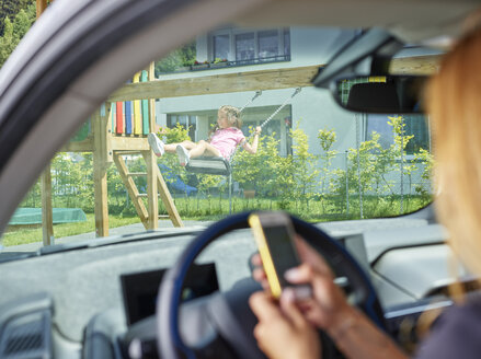 Mädchen auf einer Schaukel und Frau in einem Elektroauto, die mit einem Handy telefonieren - CVF00808