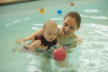 Mutter und kleine Tochter im Schwimmbad spielen mit Ball - CUF31607