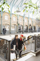 Junges Paar beim Einkaufen auf einer Treppe in Covent Garden, London, UK - CUF31682