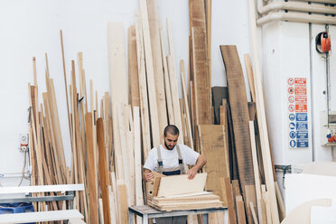 Tischler bei der Holzauswahl in der Werkstatt - CUF31725