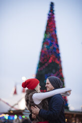 Romantic young couple hugging at xmas festival in Hyde Park, London, UK - CUF31763
