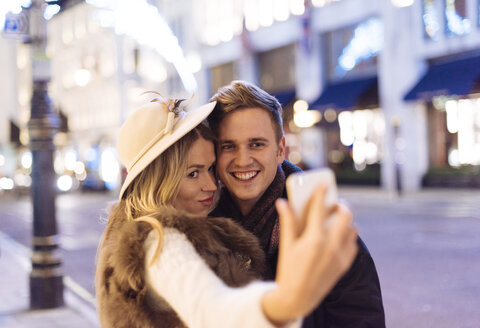 Junges Paar macht Smartphone-Selfie zu Weihnachten in der New Bond Street, London, UK - CUF31770