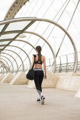 Sportive woman with sports bag walking, rear view - ACPF00041