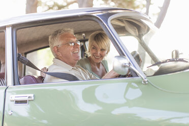 Senior man and mature woman in car together, smiling - ISF09764