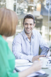 Businesswoman and man meeting at coffee break on hotel terrace - ISF09774