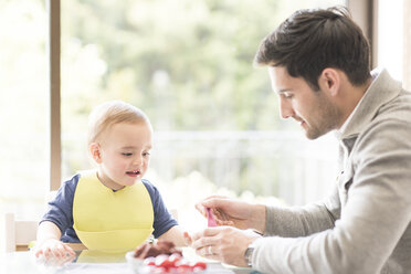 Father feeding young son, indoors - CUF31889