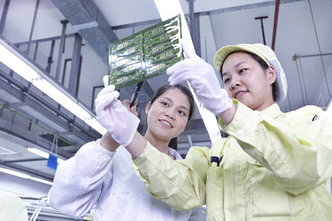 Supervisor, der die Arbeit an der Qualitätskontrollstation in einer Fabrik für flexible elektronische Leiterplatten überwacht. Das Werk befindet sich im Süden Chinas, in Zhuhai, Provinz Guangdong - CUF31972