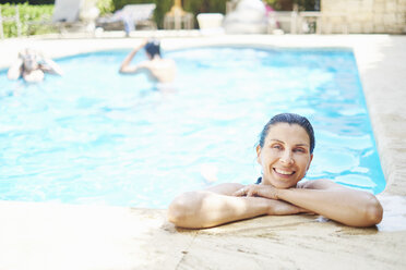 Portrait of smiling mature woman with wet hair in swimming pool - CUF32125