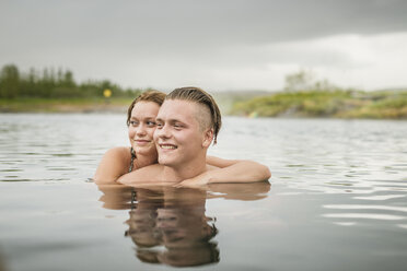 Young couple looking sideways from Secret Lagoon hot spring (Gamla Laugin), Fludir, Iceland - CUF32161