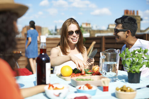 Adult friends preparing fresh finger food at rooftop party - CUF32233