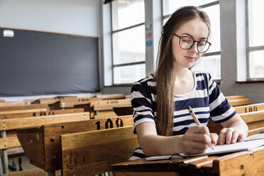 Studentin arbeitet in einem leeren Klassenzimmer - CUF32246