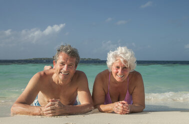 Älteres Paar am Strand liegend, Malediven - ISF09803