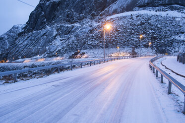 Schneebedeckte Landstraße in der Abenddämmerung, Reine, Lofoten, Norwegen - ISF09823