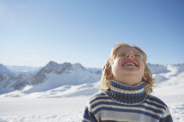 Porträt eines Jungen in einer verschneiten Landschaft, lächelnd, mit Blick nach oben - ISF09885