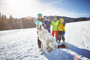 Kinder und Hund genießen das Spielen im Schnee - ISF09895