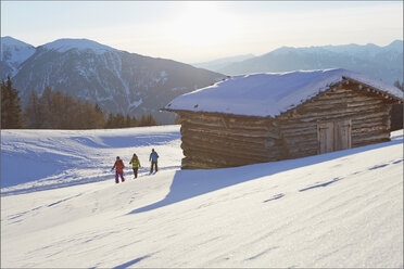 Fernblick auf drei mittelalte Freunde beim Schneeschuhwandern in den Dolomiten, Eisacktal, Südtirol, Italien - ISF09941