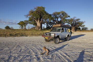 Junge spielt mit Fahrzeug, Nxai Pan National Park, Kalahari-Wüste, Afrika - ISF09953