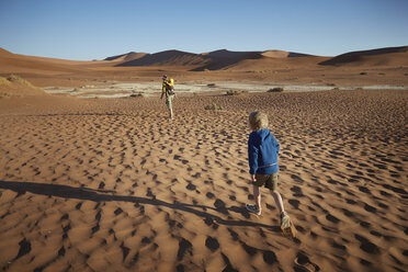 Junge geht in der Wüste spazieren, Namib Naukluft National Park, Namib Wüste, Sossusvlei, Dead Vlei, Afrika - ISF09964