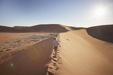 Boy walking on sand dune, Namib Naukluft National Park, Namib Desert, Sossusvlei, Dead Vlei, Africa - ISF09965