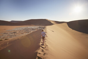 Junge läuft auf Sanddüne, Namib Naukluft National Park, Namib Wüste, Sossusvlei, Dead Vlei, Afrika - ISF09965