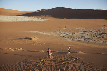 Boys walking on sand dune, Namib Naukluft National Park, Namib Desert, Sossusvlei, Dead Vlei, Africa - ISF09966