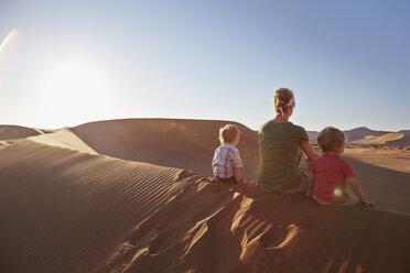 Mutter und Söhne sitzen auf einer Sanddüne, Namib Naukluft National Park, Namib Wüste, Sossusvlei, Dead Vlei, Afrika - ISF09967