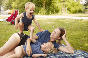 Mother and sons relaxing in park, lying on picnic blanket - ISF09986
