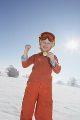 Young boy showing off medal around neck, low angle view - ISF10016