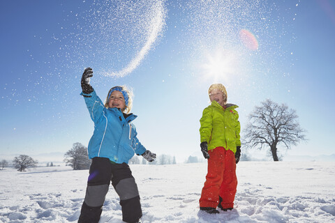 Junge Brüder spielen im Schnee, lizenzfreies Stockfoto