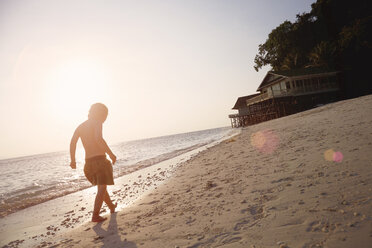 Silhouettierter Junge, der am sonnenbeschienenen Strand spazieren geht, Insel Rawa, Malaysia - ISF10039