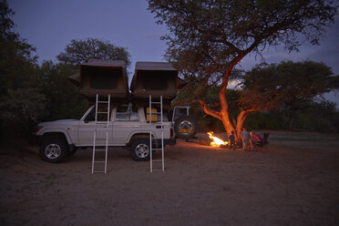 Geländewagen geparkt, Familie sitzt am Lagerfeuer, Purros, Kaokoland, Namibia - ISF10075