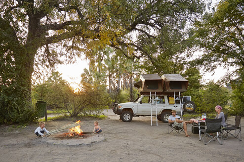 Geländewagen geparkt, Familie entspannt am Lagerfeuer, Nata, Makgadikgadi, Botswana - ISF10088