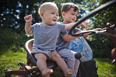 Kleiner Junge und Junge spielen auf altem Traktor - ISF10152