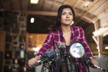 Mechanikerin bei der Arbeit an einem Motorrad in der Werkstatt - ISF10214