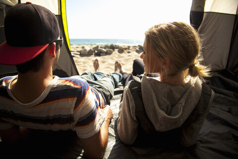Ehepaar entspannt sich im Zelt am Strand, Malibu, Kalifornien, USA, lizenzfreies Stockfoto
