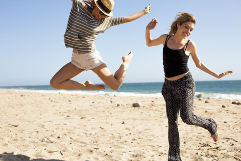 Freundinnen springen in der Luft am Strand, Malibu, Kalifornien, USA - ISF10241