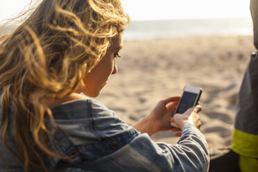 Frau benutzt Smartphone am Strand - ISF10261